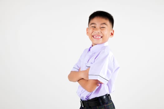 Portrait smiling Asian little boy primary posing with arms folded studio shot isolated white background, happy cute man kid wear school uniform crossed arms, back to school concept