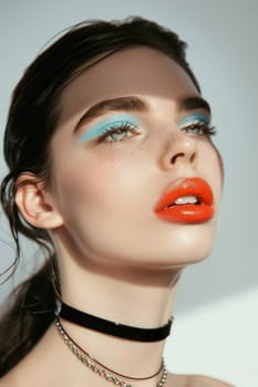 Beautiful woman with blue and orange makeup and choker on neck in fashion and beauty portrait shot