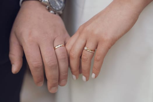 Married couple holding hands with rings wedding day