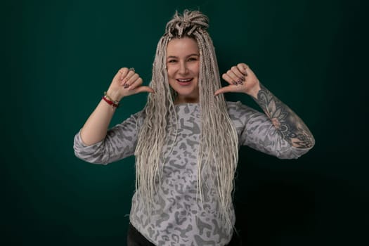 A woman with long blonde hair is striking a pose for a picture. She looks confident and stylish as she poses in front of the camera.
