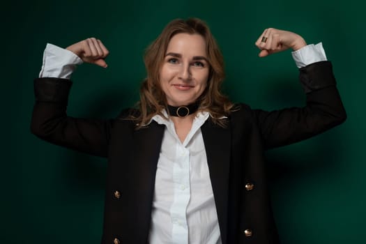 A woman wearing a black jacket and white shirt stands confidently in a casual outfit. She has a modern and stylish appearance, exuding a sense of professionalism and sophistication.