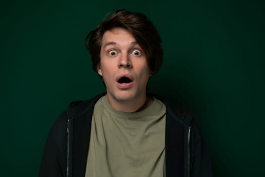 A man with a shocked expression on his face, eyes wide open and mouth slightly agape. His eyebrows raised, indicating surprise or astonishment. It is clear that something unexpected has caught his attention.