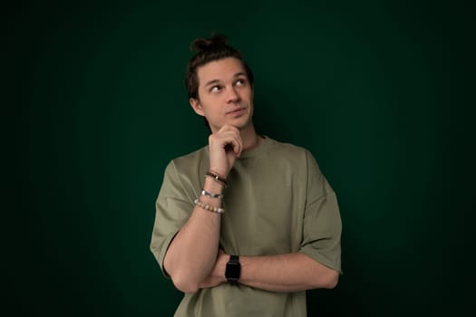A man is standing with his hand on his chin, deep in thought, contemplating something. He appears focused and introspective, as he ponders a decision or idea.