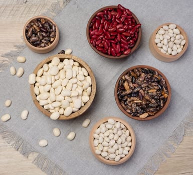 Raw white and red beans in a plate on the table, top view.