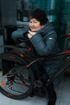 Mature European woman sat down to rest during a bike ride around the city.