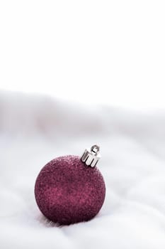 Gift decor, New Years Eve and happy celebration concept - Purple Christmas baubles on white fluffy fur backdrop, luxury winter holiday design background