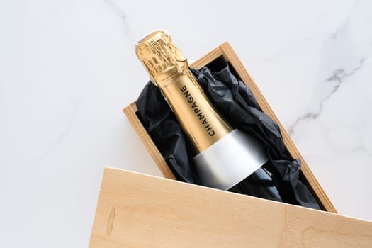 Wedding celebration, lifestyle and luxury present concept - A champagne bottle and a gift box on marble