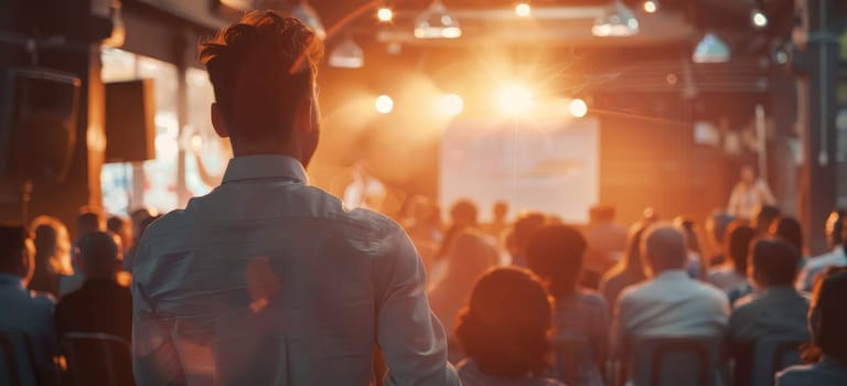 A man stands in front of a large audience, giving a speech by AI generated image.