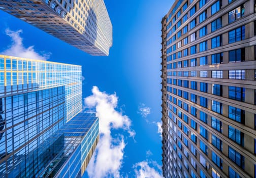 A city skyline with three tall buildings and a clear blue sky by AI generated image.