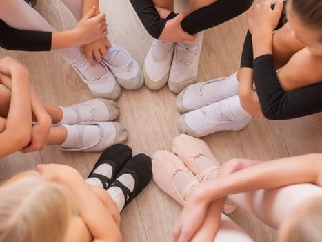 Five little ballerinas and a teacher are sitting in a circle hugging