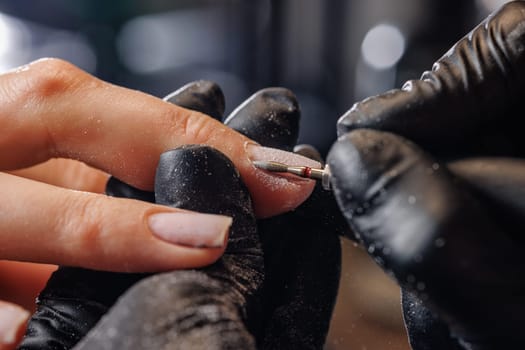 A manicurist gives a hardware manicure to a client using special tools. nail salon, self care concept