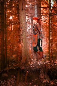 Mature model portraying a royal huntress with red curve hair is hunting with a crossbow in the in vibrant autumn forest in thematic photo shoot