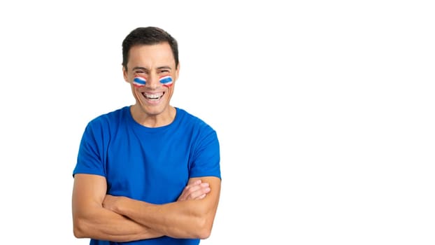 Man standing with tahi flag painted on face smiling with arms crossed