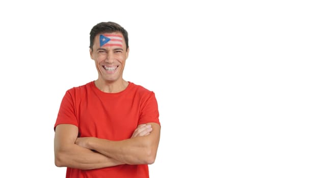 Man standing with puerto rican flag painted on face smiling with arms crossed