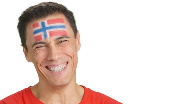 Close up of a man with a norwegian flag painted on the face smiling at camera