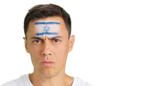 Close up of a serious man with a israeli flag painted on the face looking at camera