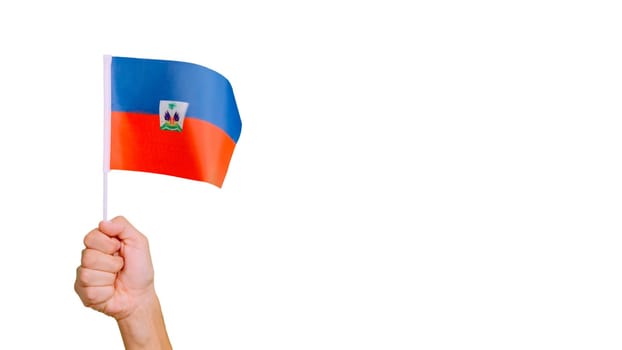 Photo of wind waving a haitian pennant holding by a hand.