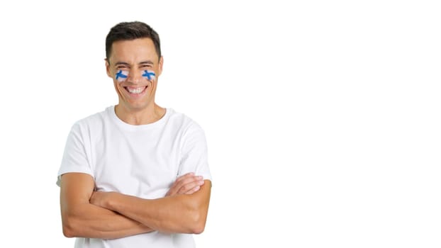 Man standing with finnish flag painted on face smiling with arms crossed