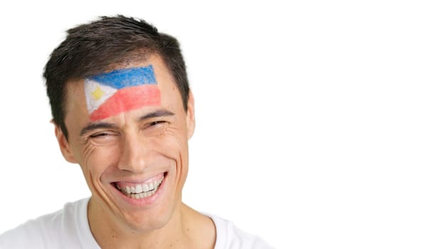 Close up of a man with a philippine flag painted on the face smiling at camera