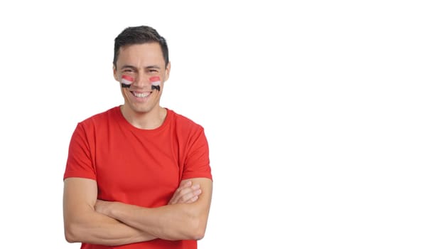 Man standing with egyptian flag painted on face smiling with arms crossed