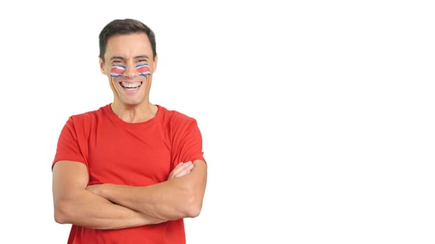 Man standing with costa rican flag painted on face smiling with arms crossed