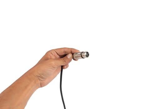 Male hand holding an XLR audio connector cable isolated on white background. High quality photo