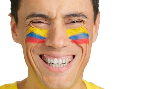 Close up of a man with a colombian flag painted on the face smiling at camera