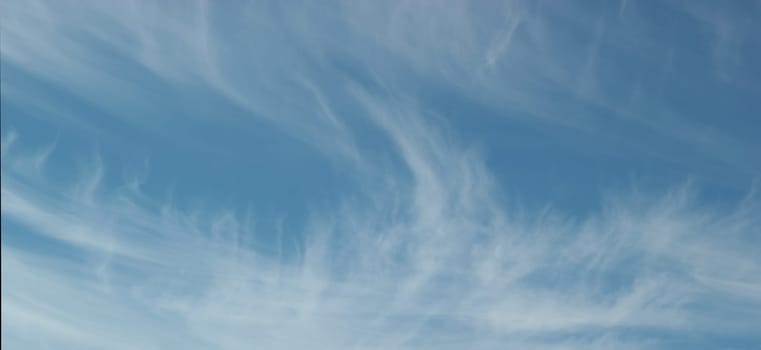 Banner aspect ratio with blue sky and winter clouds blown away by the wind, copy space, background.