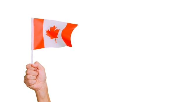 Photo of wind waving a canadian pennant holding by a hand.