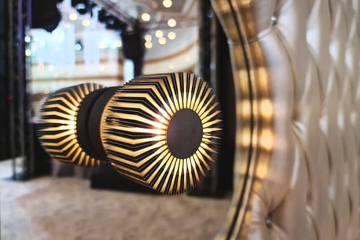 Modern wall lamp installed in a mirror in a luxurious hall interior.