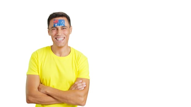 Man standing with australian flag painted on face smiling with arms crossed