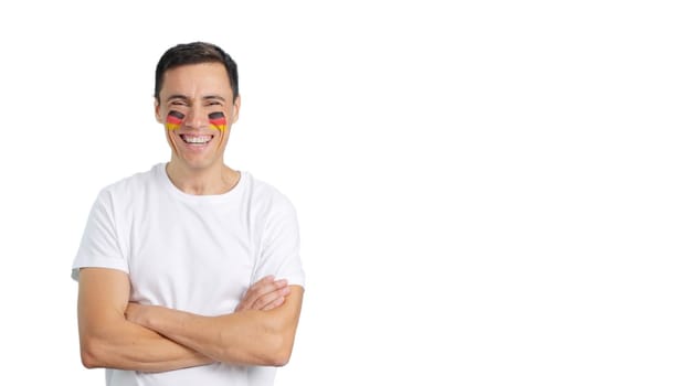 Man standing with german flag painted on face smiling with arms crossed