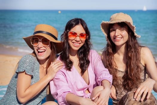 Group of smiling multiethnic women wearing hats and sunglasses enjoying vacation. Beautiful and cheerful Gen Z girls pose looking at the camera