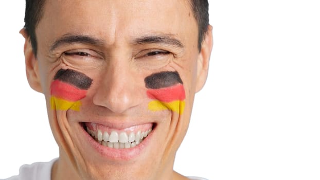 Close-up of a caucasian man with a german flag painted on the face smiling at camera