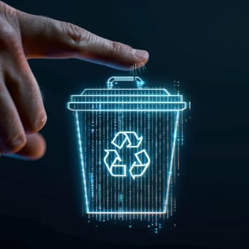 Finger touching a futuristic blue neon illuminated trash bin.