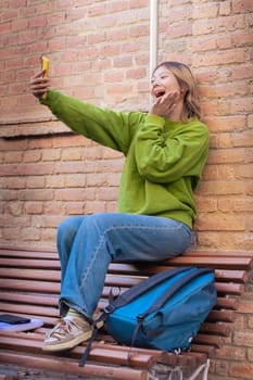 Happy young chinese taking a selfie with smartphone.