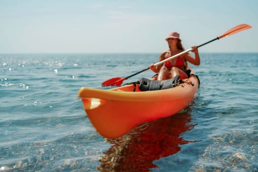 Kayak sea woman. Happy attractive woman with long hair in red swimsuit, swimming on kayak. Summer holiday vacation and travel concept