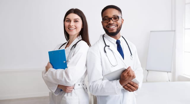 Diverse Professional Doctors In White Coats Posing To Camera At Conference Room
