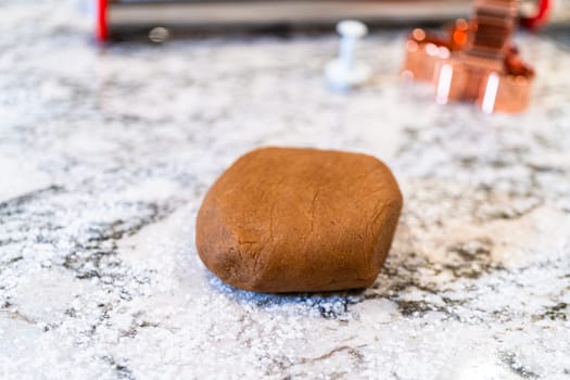 In a contemporary white kitchen, gingerbread cookie dough is skillfully rolled out, setting the stage for a delightful holiday treat.