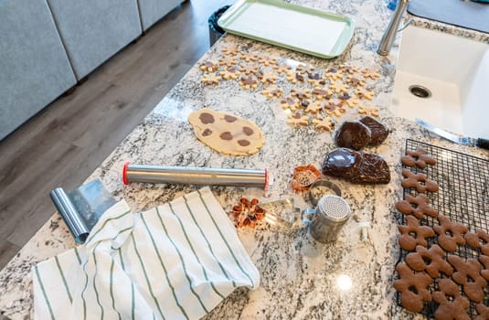 In a contemporary white kitchen, gingerbread cookie dough is skillfully rolled out, setting the stage for a delightful holiday treat.