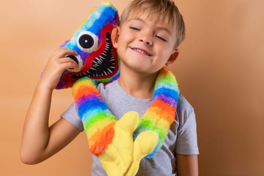 Positive little boy 6 years old with a bright colored toy. Concept: kindergarten, imaginary friend, favorite toy