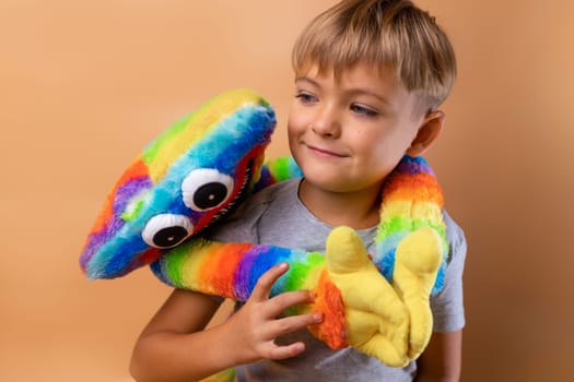 Positive little boy 6 years old with a bright colored toy. Concept: kindergarten, imaginary friend, favorite toy