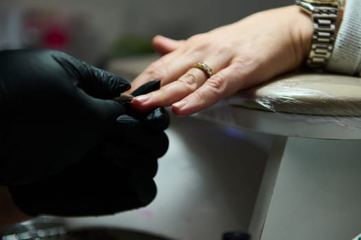 Close-up of a manicure session in a beauty salon, highlighting the professional care and precision involved in nail grooming.