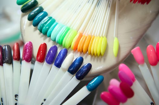 A close-up shot of assorted colorful nail polish samples arranged in a beauty salon, showcasing the variety of shades available.