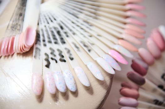 Close-up of various nail polish color samples in a beauty salon, showcasing different shades and designs for manicures.