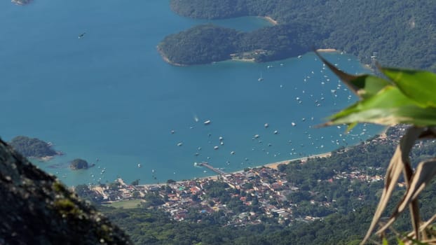 A stunning aerial video of Ilha Grande, Brazil, featuring dense forests, rocky shores, coastal boats, and the town of Abrao.