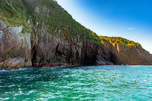 Rocky cliff over the sea on the island of Ilhabela in Sao Paulo at sunset