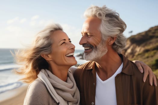 Summer portrait of happy smiling mature gray-haired couple standing together on sunny coast, woman and man enjoying beach vacation at sea