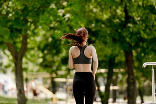 Young Girl Enjoys Morning Run In Park, View From Behind