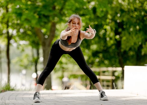 Sporty Teenage Girl Does Bends In Park During Summer